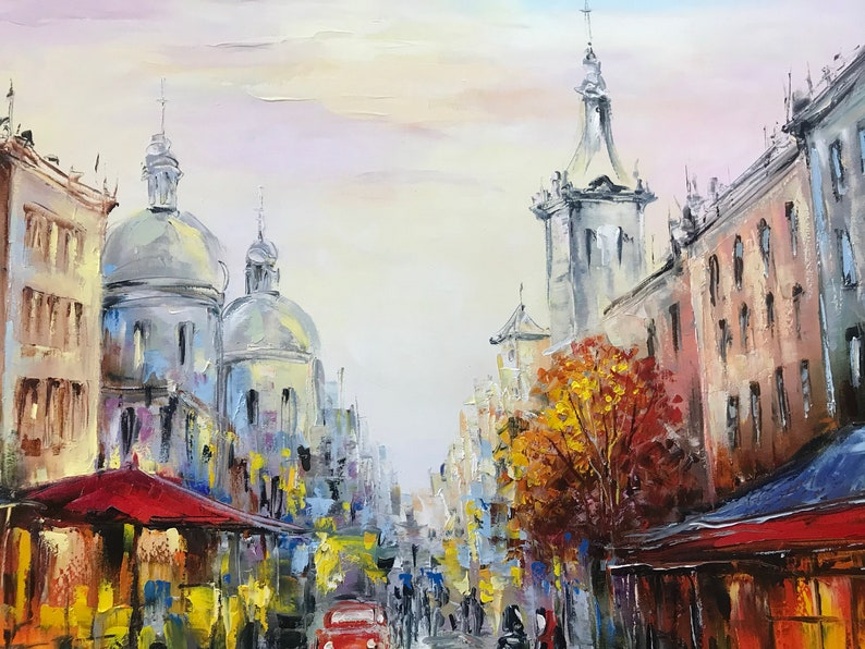 May include: Oil painting of a European city street scene. The artwork depicts buildings with domed roofs and a red awning. A red car is driving down the street, and people are walking on the sidewalks. The color palette includes blues, yellows, and reds.