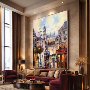 May include: Large framed oil painting of a European city street scene with a red tram, buildings, and figures. The artwork uses a warm colour palette with red, yellow, and blue highlights. The painting is displayed above a burgundy sofa.