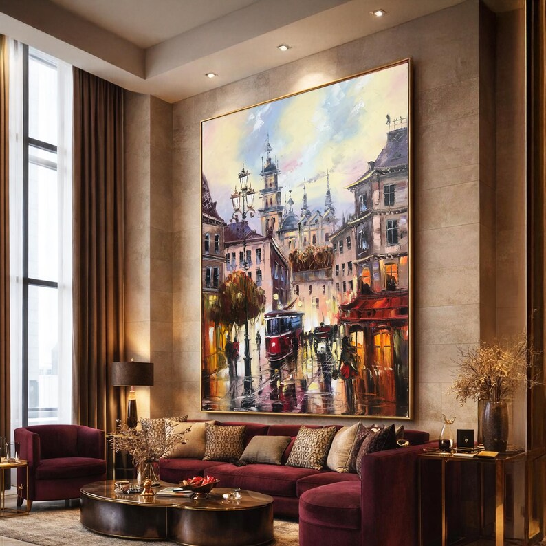 May include: Large framed oil painting of a European city street scene with a red tram, buildings, and figures. The artwork uses a warm colour palette with red, yellow, and blue highlights. The painting is displayed above a burgundy sofa.