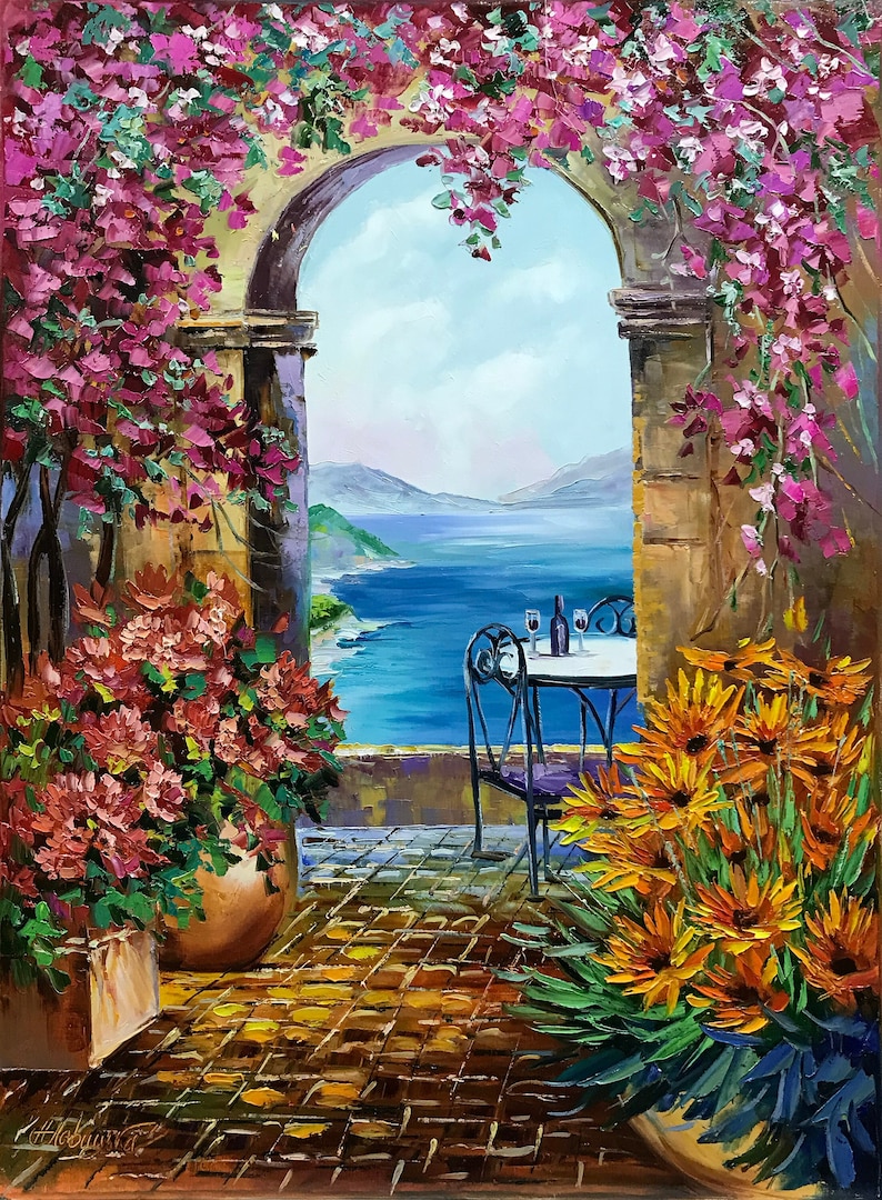 May include: A painting of a stone archway with a view of a blue ocean and mountains in the distance. There is a table and chairs set for two with a bottle of wine and glasses. The archway is covered in pink flowers and there are yellow flowers in the foreground.