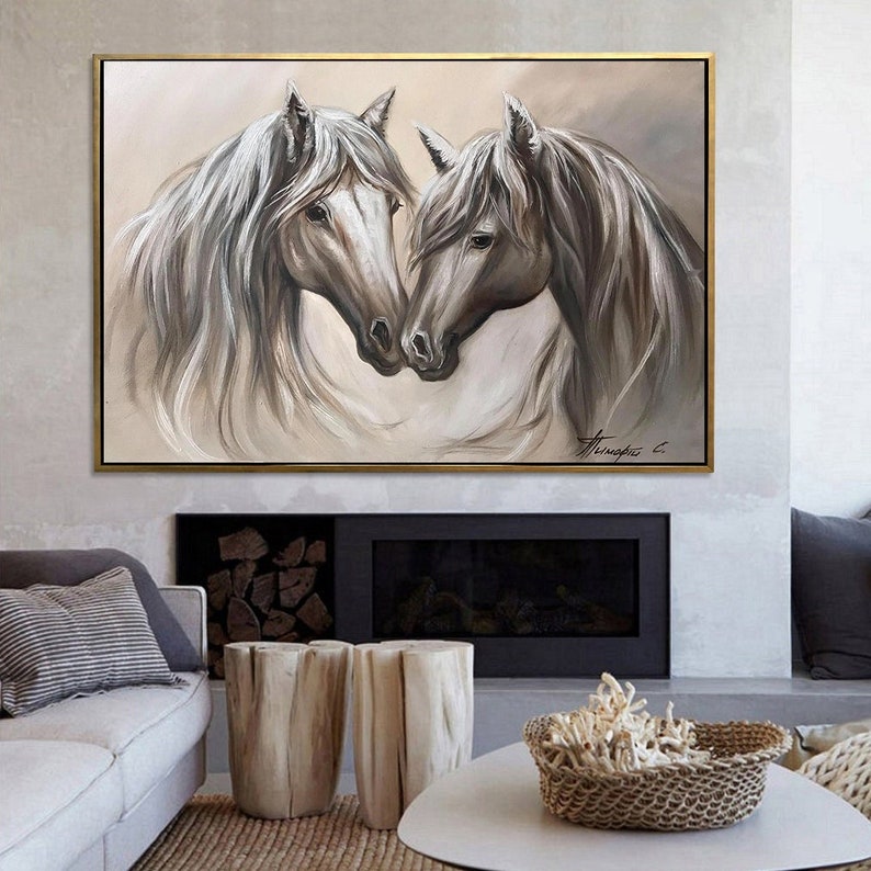 May include: An oil painting of two horses, heads touching, in shades of gray and white. The horses have long, flowing manes and are set against a neutral background. The artwork is framed in a gold-colored frame.