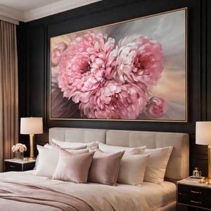 May include: A bedroom features a large framed painting of pink peonies. The artwork is set against a dark wall. The bedroom includes a bed with a beige headboard, white and pink pillows, and matching bedding. The room is decorated in neutral tones.