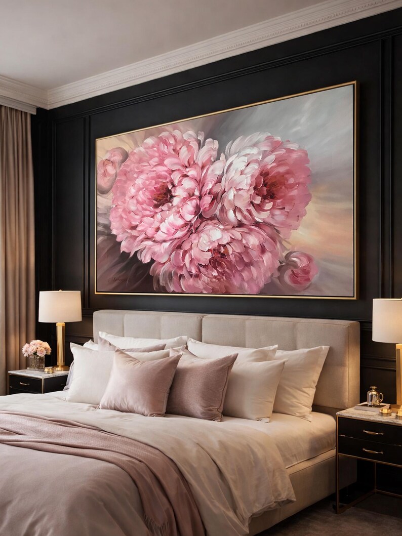 May include: A bedroom features a large framed painting of pink peonies. The artwork is set against a dark wall. The bedroom includes a bed with a beige headboard, white and pink pillows, and matching bedding. The room is decorated in neutral tones.