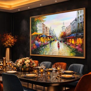 May include: A large framed oil painting depicts a European street scene with cafes, people, and colorful buildings. The artwork hangs above a dining table set for a meal, with flowers and candles.