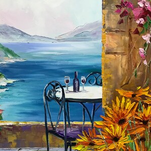 Puede incluir: Una pintura al &oacute;leo que muestra una escena costera con una mesa redonda y dos sillas en un patio de piedra. Una botella y dos copas descansan sobre la mesa. En primer plano, flores naranjas crecen junto a un muro de piedra con flores rosas.