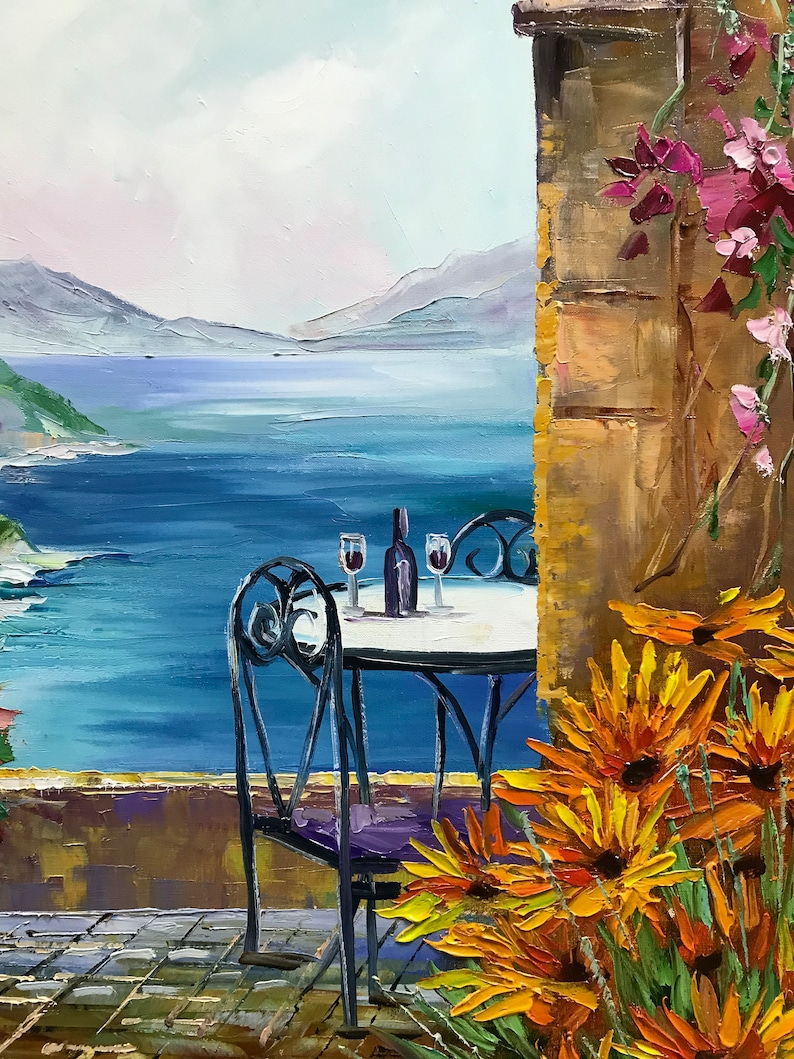 Puede incluir: Una pintura al &oacute;leo que muestra una escena costera con una mesa redonda y dos sillas en un patio de piedra. Una botella y dos copas descansan sobre la mesa. En primer plano, flores naranjas crecen junto a un muro de piedra con flores rosas.
