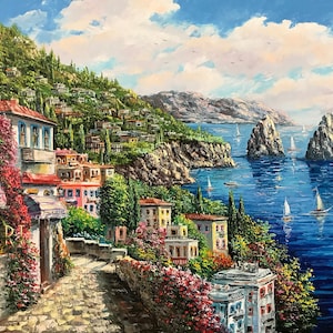 May include: A painting of a colorful Italian village nestled on a hillside overlooking a blue sea with two rocky islands in the distance. Sailboats dot the water and the sky is a bright blue with white clouds.