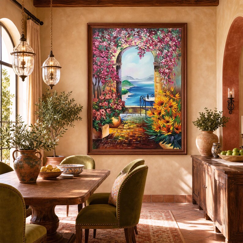 Puede incluir: Un cuadro al &oacute;leo rectangular con marco que representa una escena de terraza mediterr&aacute;nea con un arco de piedra, buganvillas rosas, girasoles amarillos y una vista al mar azul, colgado en una pared de tonos c&aacute;lidos en un comedor.