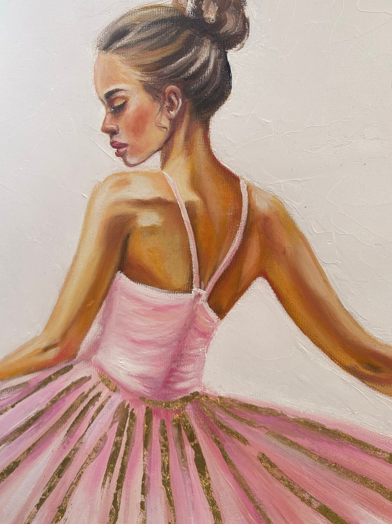 May include: A painting of a ballerina wearing a pink tutu with gold accents. The ballerina is facing away from the viewer and has her hair pulled back in a bun.