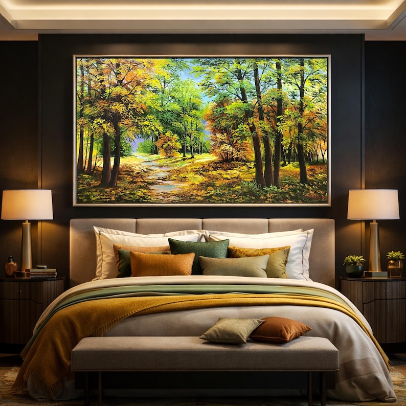 May include: A large framed landscape painting of a forest scene with a path. The painting hangs above a bed with a gray headboard, white pillows, and a mustard-colored blanket. Two lamps sit on nightstands.