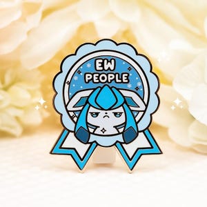 May include: A light blue and white enamel pin shaped like a ribbon award. The center features a stylized character with a grumpy expression and the text EW PEOPLE in black letters. The design includes small white snowflake accents on a blue background.