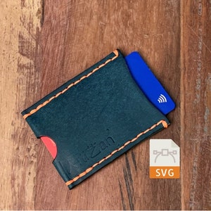 May include: A black leather card holder with orange stitching. The holder has a slot for a card and the text "Kitzan" is embossed on the front.
