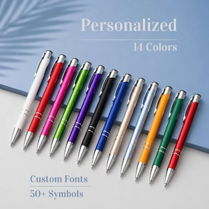 Può includere: Una collezione di 12 penne colorate con dettagli argentati, disposte diagonalmente su uno sfondo blu. Le penne sono disponibili in vari colori, tra cui bianco, rosso, rosa, verde, viola, nero, blu e oro. Il testo sull'immagine recita "Personalizzato", "14 Colori", "Caratteri personalizzati" e "50+ Simboli".