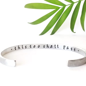 Pode incluir: Pulseira de prata com a inscrição "...this too shall pass."