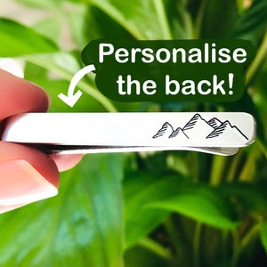 May include: Silver tie bar with a mountain range design. The back of the tie bar can be personalised.