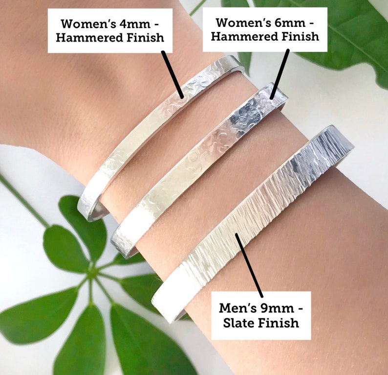 May include: Three silver bracelets with different widths and finishes. The bracelets are stacked on a person's wrist. The top bracelet is labeled "Women's 4mm - Hammered Finish", the middle bracelet is labeled "Women's 6mm - Hammered Finish", and the bottom bracelet is labeled "Men's 9mm - Slate Finish".