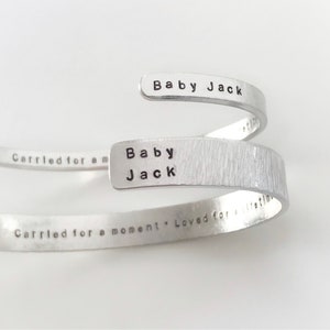 May include: Silver bracelet with the words "Baby Jack" and "Carried for a moment. Loved for a lifetime" engraved on it.