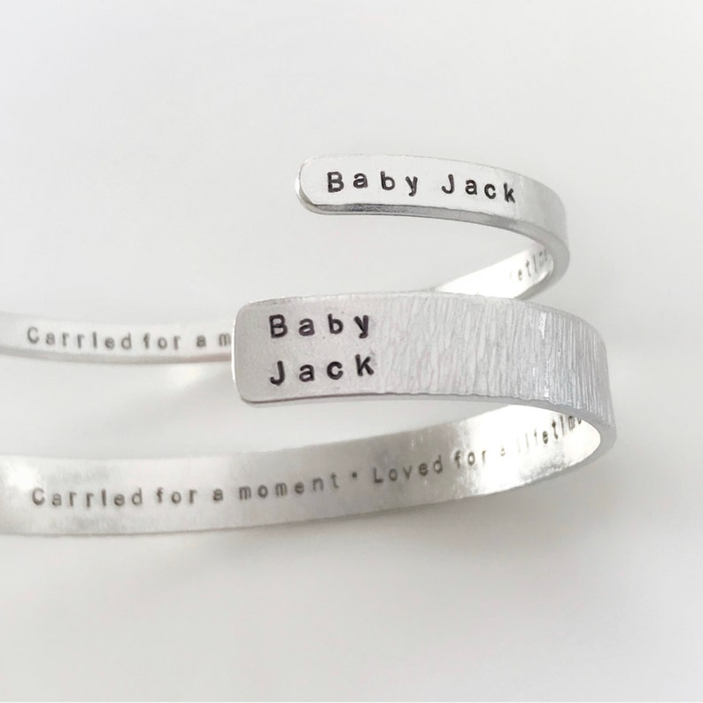 May include: Silver bracelet with the words "Baby Jack" and "Carried for a moment. Loved for a lifetime" engraved on it.