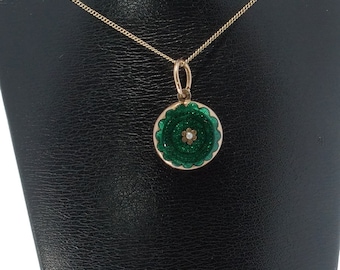 May include: A gold chain necklace with a green enamel pendant featuring a white pearl flower in the center.