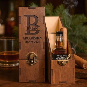 Puede incluir: Caja de regalo de madera para padrino, grabada con el nombre "BRIAN" y la fecha "9 de julio de 2025". Contiene una botella en miniatura de Jack Daniel's y un cigarro. La caja se cierra con un cierre metálico.