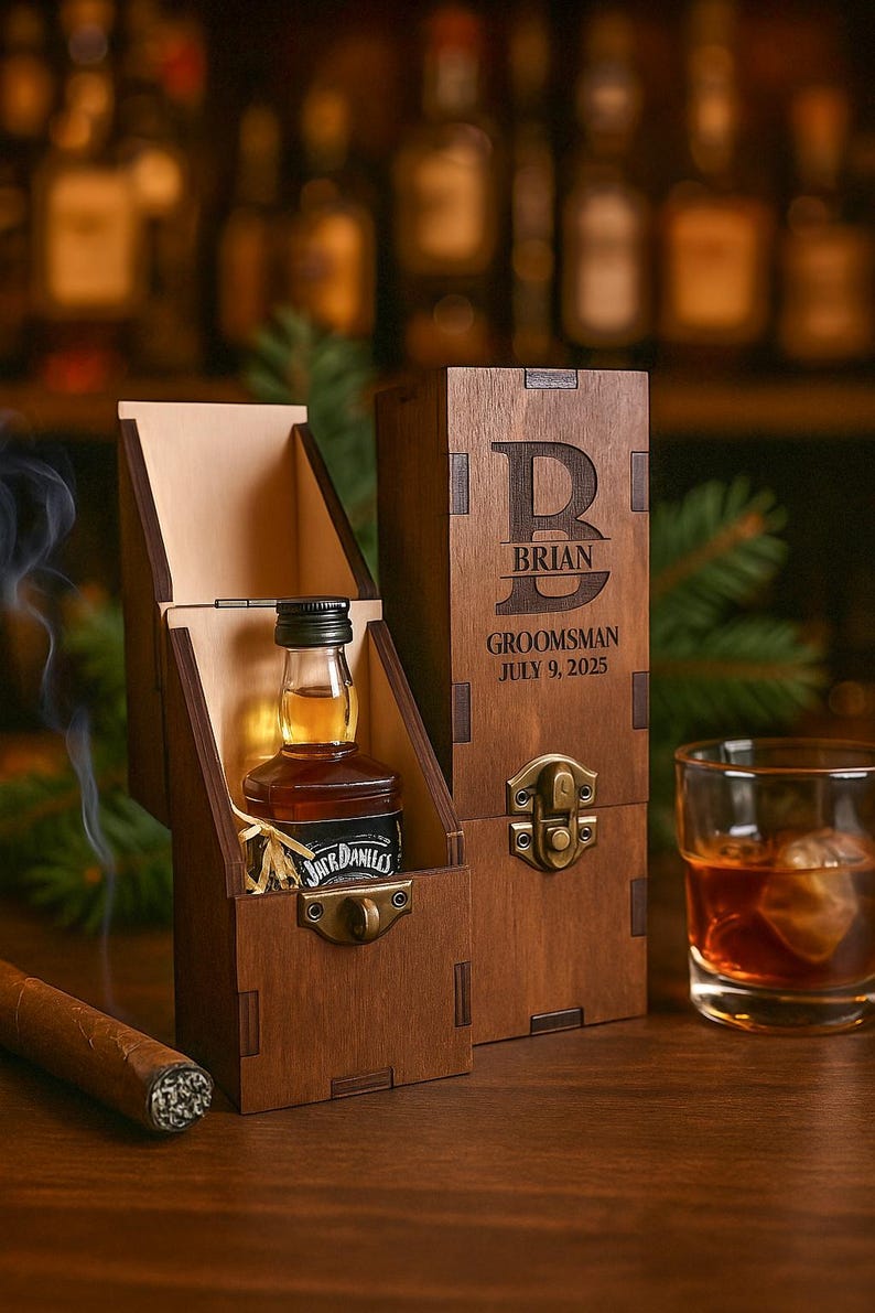 May include: A wooden gift box with a small bottle of Jack Daniel's whiskey inside. The box is open, revealing the bottle and a decorative interior. A cigar and a glass of whiskey are also present.
