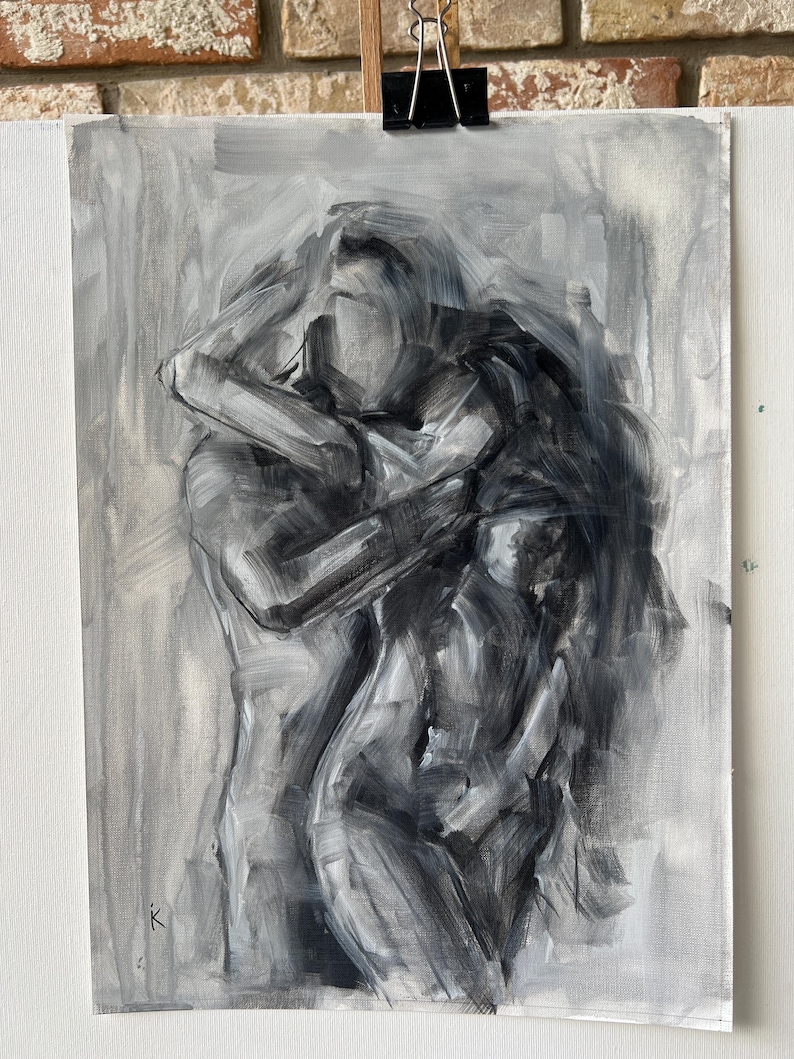May include: Monochromatic oil painting on canvas depicting a tender embrace between two figures. The artwork, rendered in shades of gray, features expressive brushstrokes and a focus on form and emotion. The painting is mounted on a white surface.