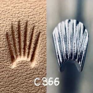 Könnte beinhalten: Nahaufnahme eines silbernen Kronenlogos, das auf eine braune Lederoberfläche geprägt ist. Die Krone hat ein detailliertes Design mit einem gewellten Rand. Der Text "C366" ist unterhalb der Krone gedruckt.