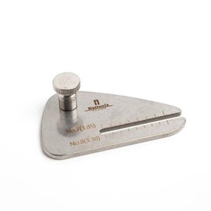 May include: A silver metal ring mandrel tool with a graduated scale and a knob on top. The tool is labelled "No. 7 (3.85)" and "No. 8 (3.38)".