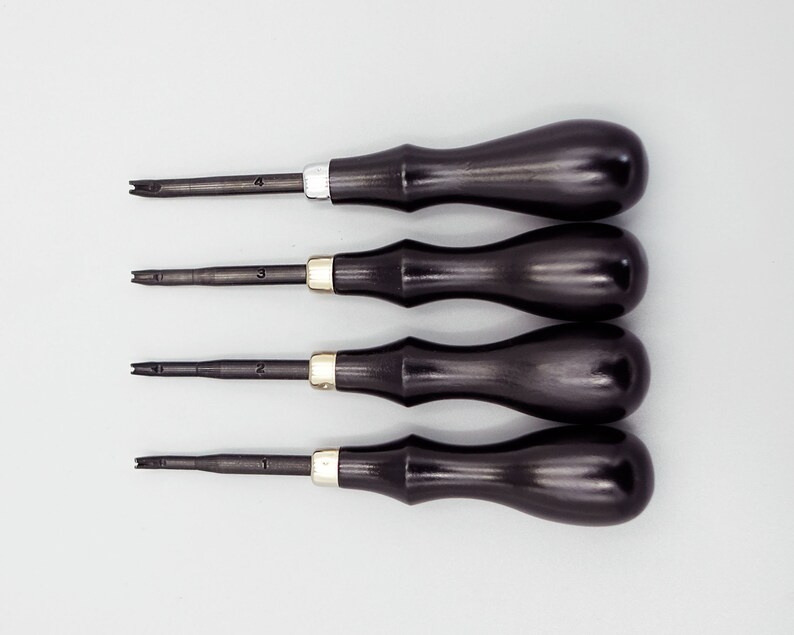 May include: Set of four black handled tools with metal tips, numbered 1 through 4. The tools are used for leather crafting.