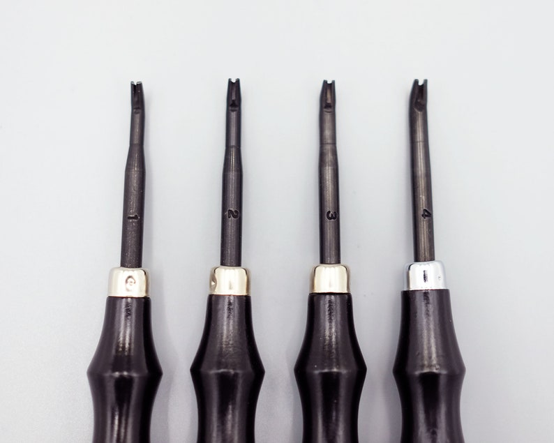 May include: Four black handled tools with different shaped tips, numbered 1 through 4. The tools are used for leather crafting.