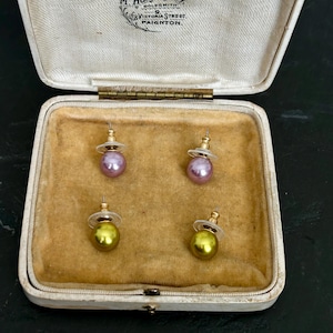 Gesigneerde Joan Rivers oorbellen uit de jaren 80 met metallic parels, in een doosje met verwisselbare vloeibare olijfgroene, lila en roze imitatieparels, inclusief achterkantje.