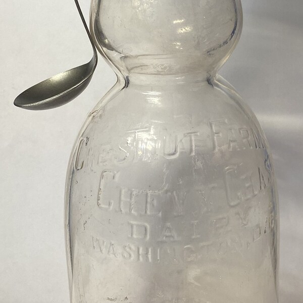 A Vintage Cream Top Milk Bottle With A Cream Top Spoon