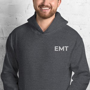 May include: Dark gray hooded sweatshirt with the word "EMT" embroidered on the front in white.