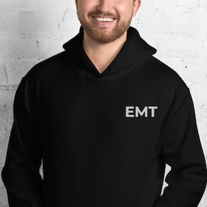 May include: Black hooded sweatshirt with the word "EMT" embroidered on the front in white.