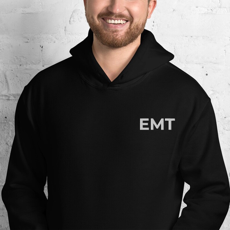 May include: Black hooded sweatshirt with the word "EMT" embroidered on the front in white.