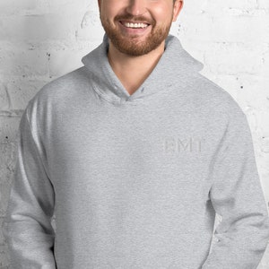 May include: A heather gray hooded sweatshirt with the word "EMT" embroidered on the front in white.