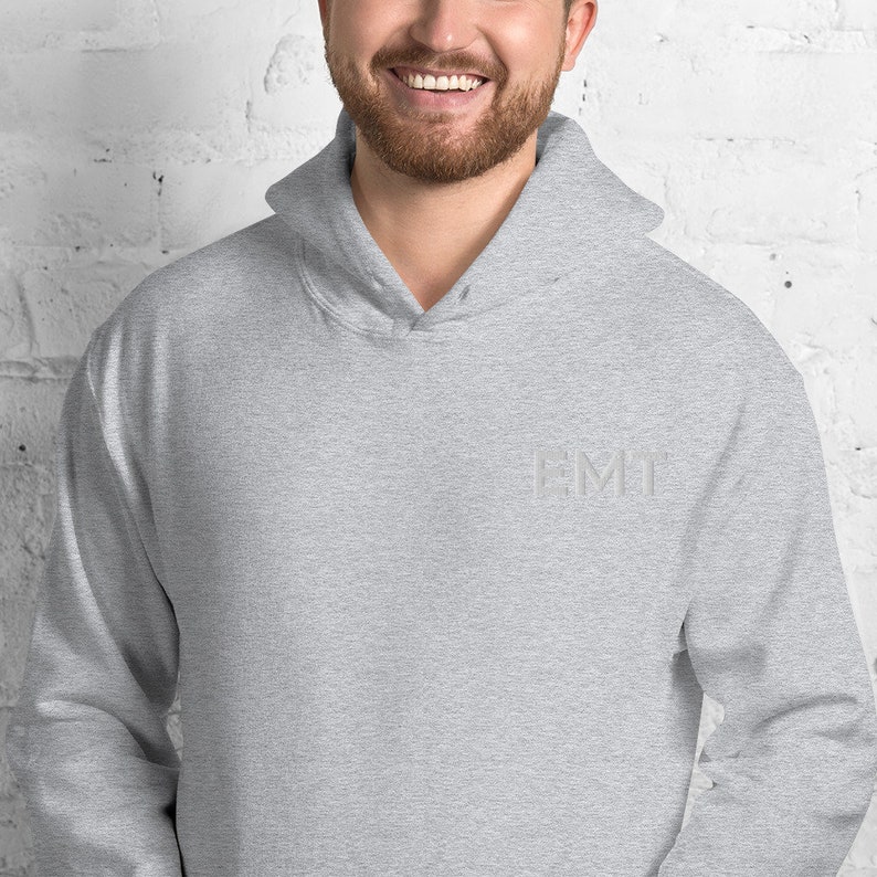 May include: A heather gray hooded sweatshirt with the word "EMT" embroidered on the front in white.