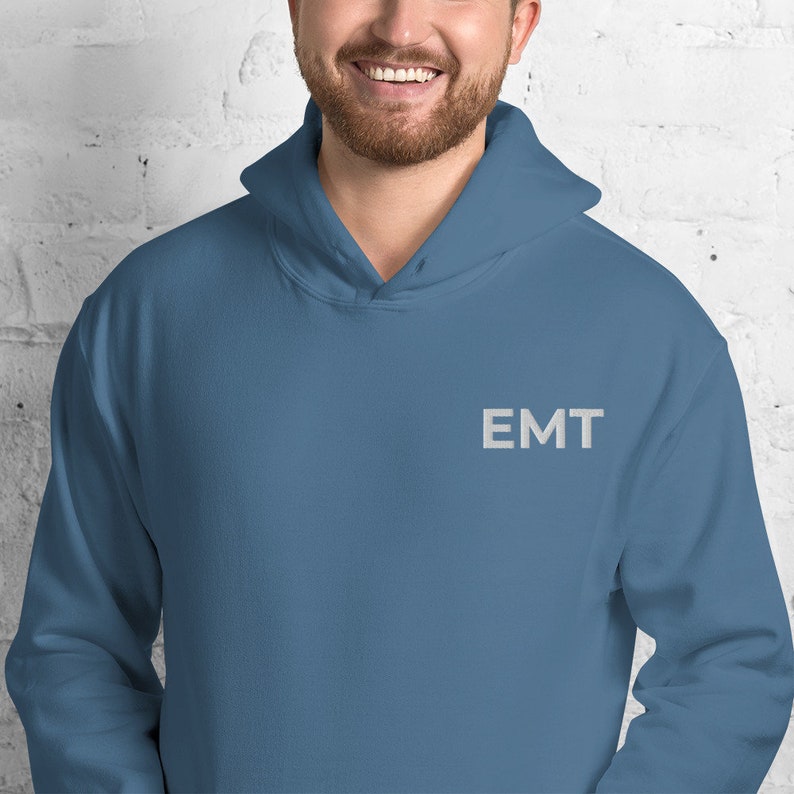 May include: A blue hooded sweatshirt with the word "EMT" embroidered on the front in white.