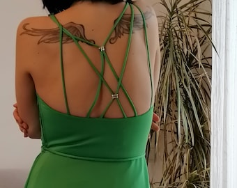 May include: A green sleeveless dress with a criss-cross back detail and a flowing skirt.