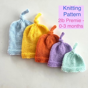 Könnte beinhalten: Fünf gestrickte Baby-Mützen in verschiedenen Farben: Hellblau, Gelb, Orange, Lila und Mintgrün. Jede Mütze hat eine geknotete Oberseite. Das Bild enthält den Text "Knitting Pattern 2lb Premie - 0-3 months."