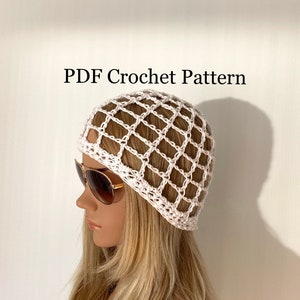 Pode incluir: Chapéu branco de crochê com um padrão de grade quadrada. O chapéu está em uma cabeça de manequim com cabelo longo e loiro. O texto "PDF Crochet Pattern" está no topo da imagem.
