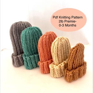 Puede incluir: Una colección de cinco gorros de bebé tejidos en varios colores: gris, verde azulado, naranja, crema y marrón. Los gorros son acanalados y tienen un borde doblado. El texto en la imagen dice: "Pdf Knitting Pattern 2lb Premie-0-3 Months."