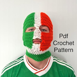 May include: A crocheted balaclava in green, white, and red, covering the head and neck. The text "Pdf Crochet Pattern" is visible on the right side. The person is wearing a green jersey with white stripes.