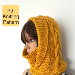 May include: Mustard yellow knitted hood with a cable knit design on the side. The hood is made of a soft, textured yarn and is designed to cover the head and neck. The image includes the text "Pdf Knitting Pattern" in a yellow box.