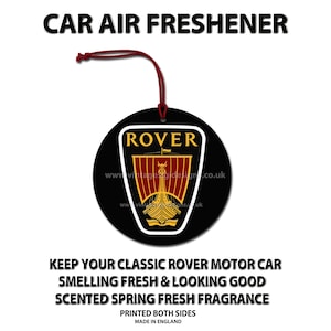 May include: Black round car air freshener with the word "ROVER" and a logo of a ship. The freshener has a red string for hanging and the text "CAR AIR FRESHENER". It is scented with a spring fresh fragrance.