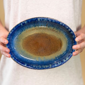 May include: A blue and brown oval ceramic serving dish with a glazed finish.