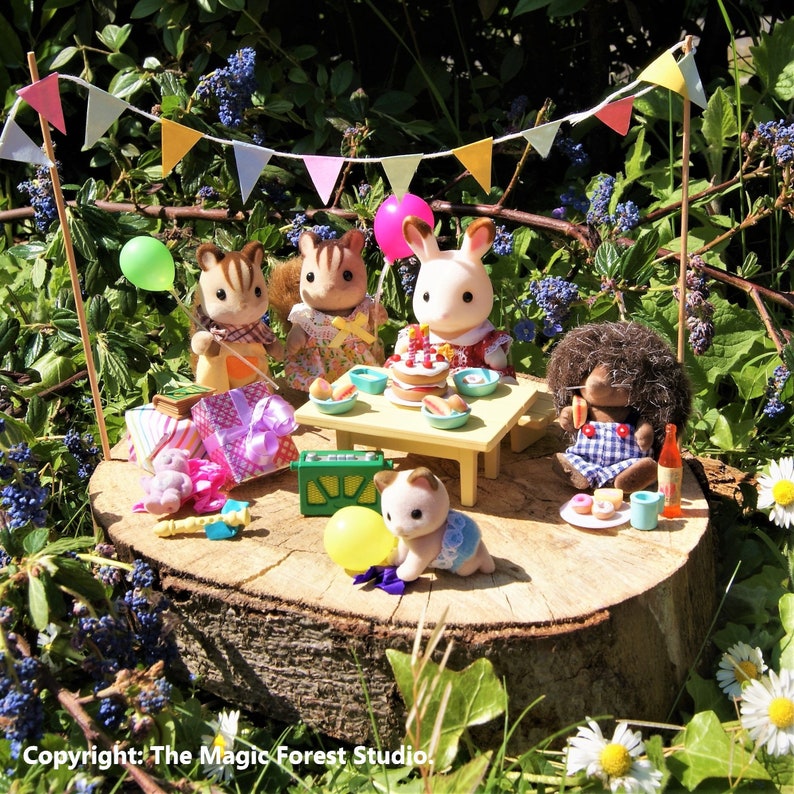 Calico Critters enjoy a birthday party deep in the forest, with gifts, cakes and balloons.