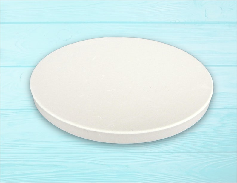 May include: A white round cake board, ideal for decorating cakes and pastries. The board is smooth and has a slightly textured surface.
