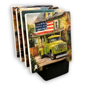 May include: Set of four ceramic coasters with watercolor images of a house with an American flag, a green truck, and other landscape scenes. The coasters are displayed in a black holder. The brand name "gencraft" is visible on the bottom of the coasters.