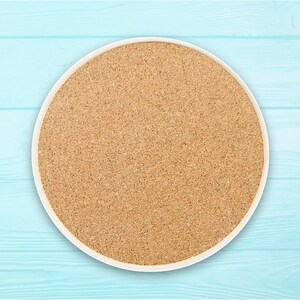 May include: A round cork coaster with a white rim. The coaster is made of natural cork and has a light brown colour.